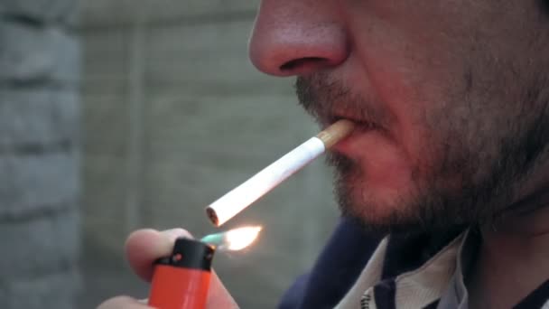 Mies sytyttämässä savuketta ulkona
 - Materiaali, video
