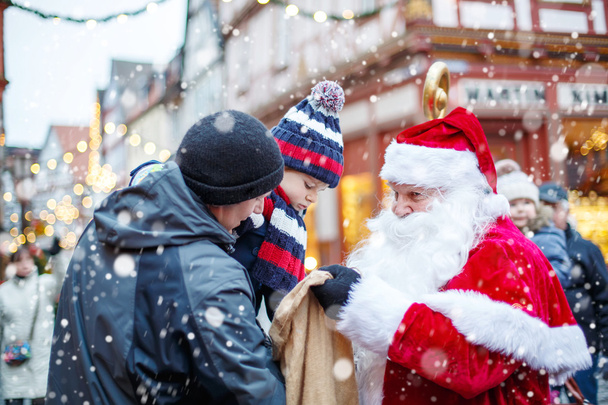 Little toddler boy with father and Santa Claus on Christmas market - Photo, Image