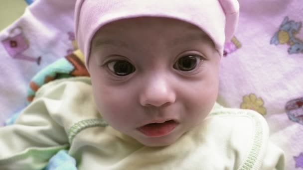 Noworodek z duże brązowe oczy rozglądając się - Materiał filmowy, wideo