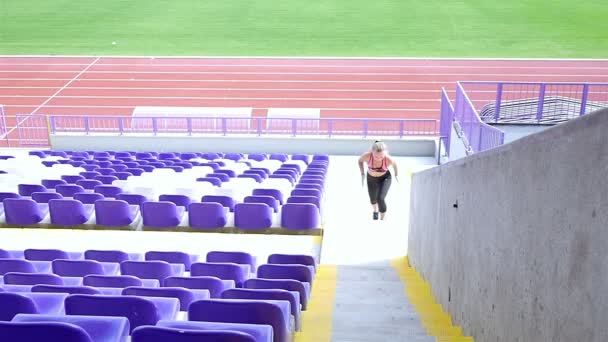 Tiener meisje atleet lopen de trap in een stadion, slow-motion - Video