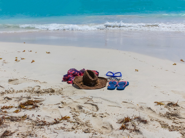 Chapeau de paille, masque. lunettes de soleil et tongs sur une plage tropicale
 - Photo, image