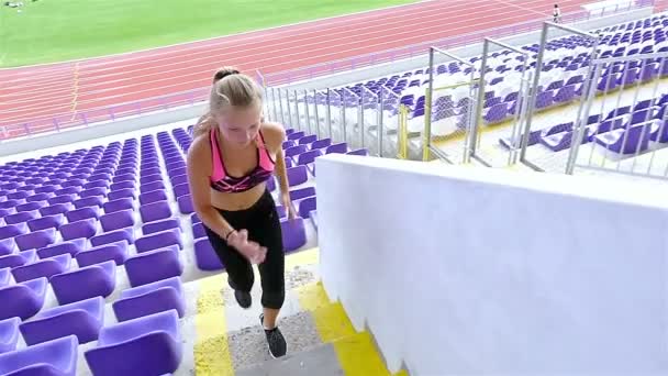 Дівчина-підліток спортсмен біжить по сходах на стадіоні, повільний рух
 - Кадри, відео