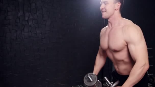 Az ember az edzőteremben egy súlyzó - Felvétel, videó