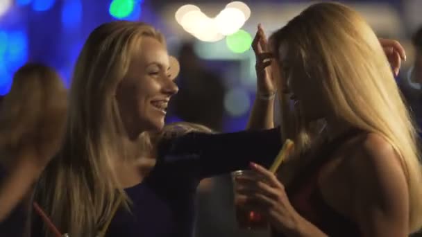 Bisexuales calientes damas abrazando y riendo en pista de baile en la fiesta de discoteca
 - Imágenes, Vídeo
