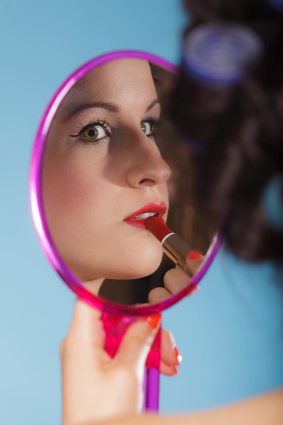  Girl applying make up red lipstick - 写真・画像