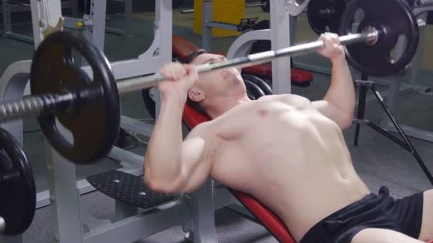 Joven banco presionando pesas en un gimnasio
 - Metraje, vídeo