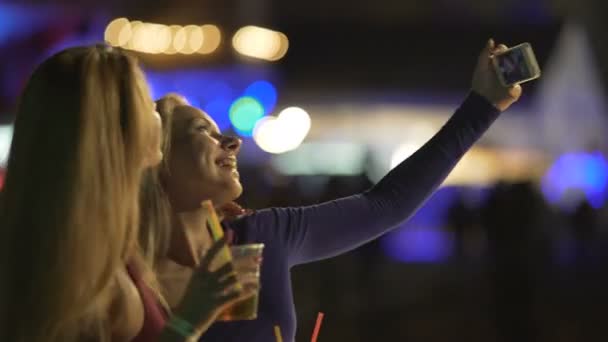Mooie vrouwelijke vrienden poseren voor selfie met cocktails, bewonderende zelfportretten - Video
