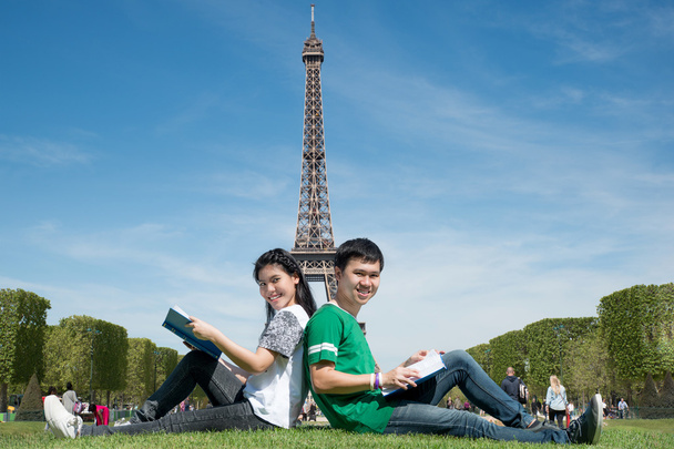 Азиатская пара студентов читает книгу вместе в открытом парке рядом
 - Фото, изображение