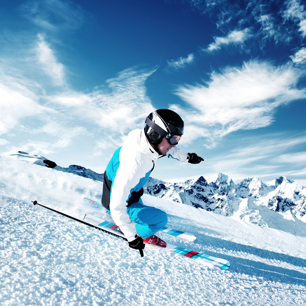 Skier in mountains, prepared piste and sunny day - Photo, Image