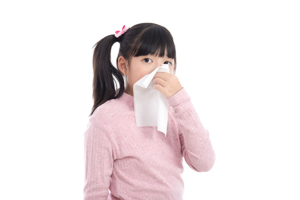 Asijská dívka fouká nos na bílém pozadí  - Fotografie, Obrázek