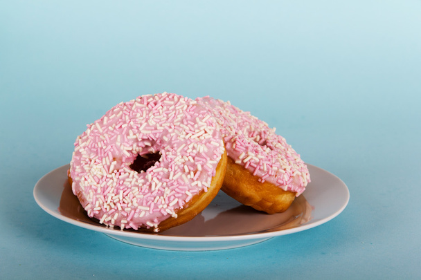Iced donut op een licht blauwe achtergrond - Foto, afbeelding