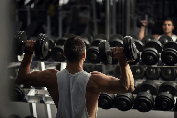 Confident strong weightlifter having a workout - Foto, Imagen