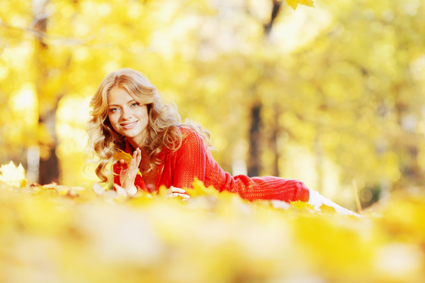 Woman laying in autumn park - Фото, изображение