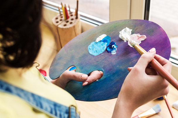 крупним планом художник змішує пензлик для фарби на мольберті
 - Фото, зображення