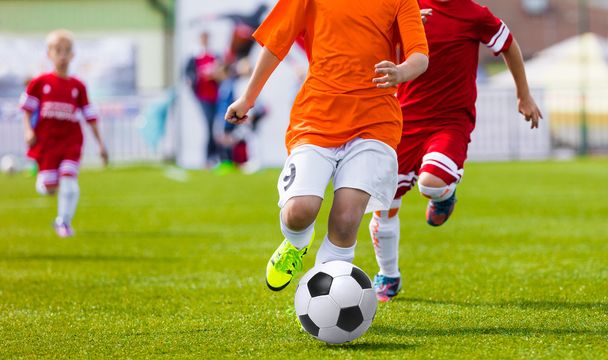 若いサッカー サッカー選手がスポーツ フィールドにはサッカー ボールを蹴るします。チームの青少年サッカーの国際サッカー リーグ大会 - 写真・画像