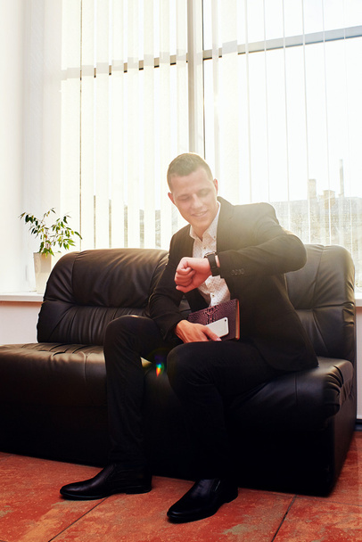 Young corporate executive sitting comfortably in a stylish chair - 写真・画像