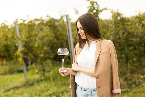 Woman with glass of wine in vineyard - Photo, Image