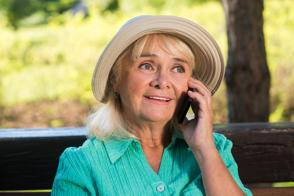 Η ηλικιωμένη γυναίκα στο τηλέφωνο.. - Φωτογραφία, εικόνα