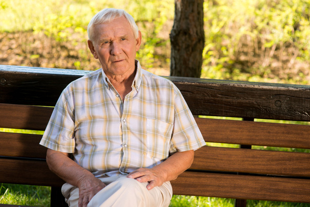 Elderly man on a bench. - Zdjęcie, obraz