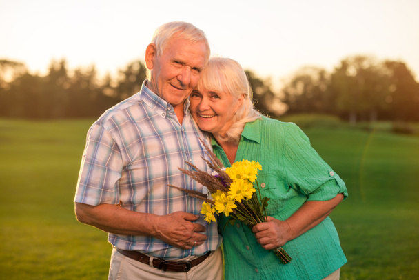 Usměvavá starší pár s kyticí - Fotografie, Obrázek