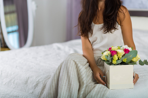 Mujer con una hermosa caja de sombreros con flores
 - Foto, imagen