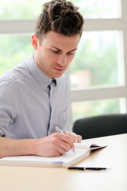 Young adult man writing note - Фото, зображення