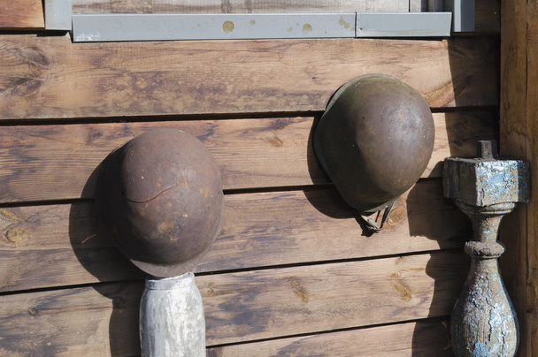 Vieux casques militaires rouillés accrochés au mur
 - Photo, image