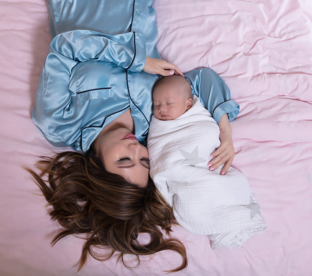 Μητέρα και το μωρό κοιμάται μαζί ενώ στο κρεβάτι - Φωτογραφία, εικόνα