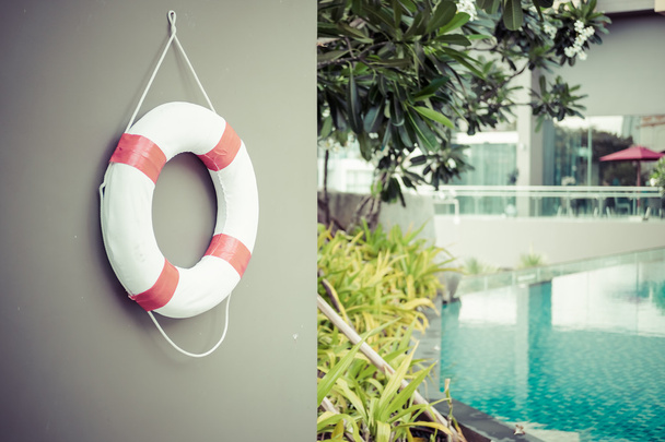 Life Buoy attached to grey wall near swimming pool with copy space - Photo, Image
