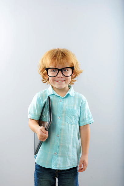 child in glasses with portable computer isolated on grey - Foto, Imagem