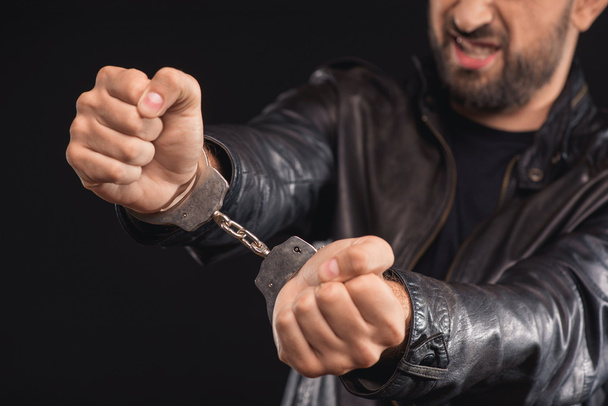Чоловік-злочинець позбавляється наручників
 - Фото, зображення