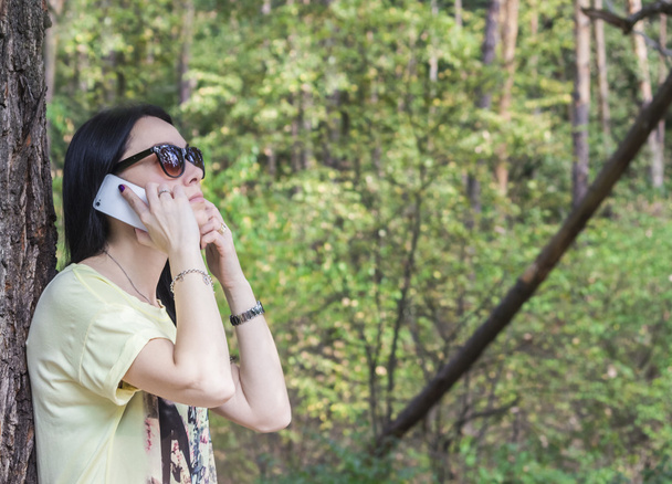 елегантна брюнетка дівчина восени говорить по телефону
 - Фото, зображення