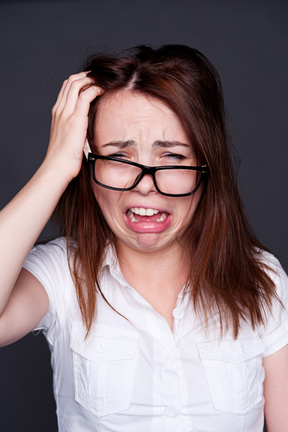 сумна молода жінка в окулярах плаче
 - Фото, зображення