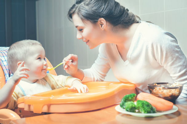 Mom feeds the baby soup. Healthy and natural baby food - Foto, afbeelding