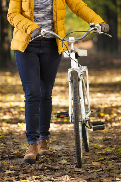 Girl walking with a bicycle at the park - Foto, imagen