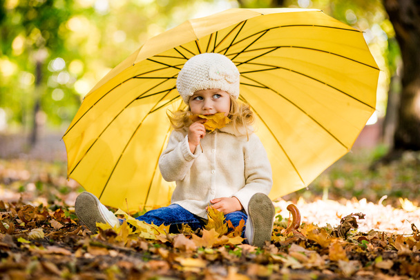 Όμορφο κοριτσάκι κίτρινο με ομπρέλα στο πάρκο - Φωτογραφία, εικόνα