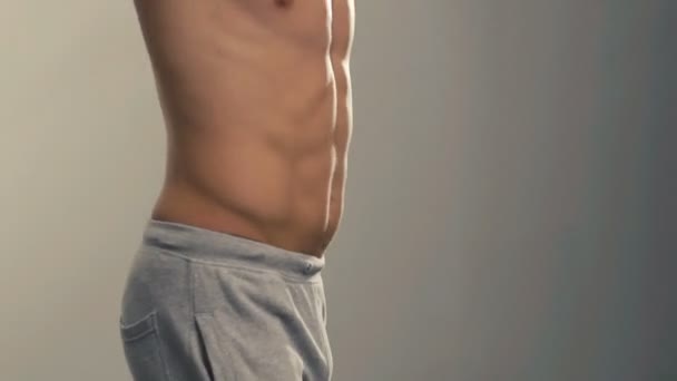Handsome sportsman kneads body in the gym - Záběry, video