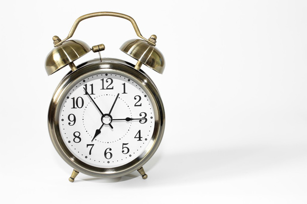 白い背景の目覚まし時計 /時計や時計と時間の概念 / ヴィンテージ目覚まし時計 / 白い背景を隔離する金属目覚まし時計  - 写真・画像