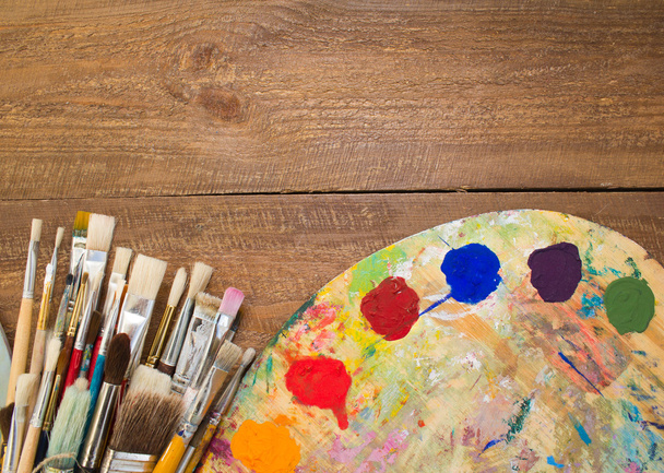 Paints, brushes and palette on the wood background.  - 写真・画像