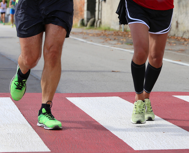 juoksijat maratonjuoksun aikana kaupungissa jalankulkijoiden ristillä
 - Valokuva, kuva