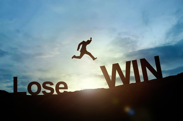 Силуэт бизнесмена светящийся прыжок Проиграй Победителю. концепция успеха
 - Фото, изображение