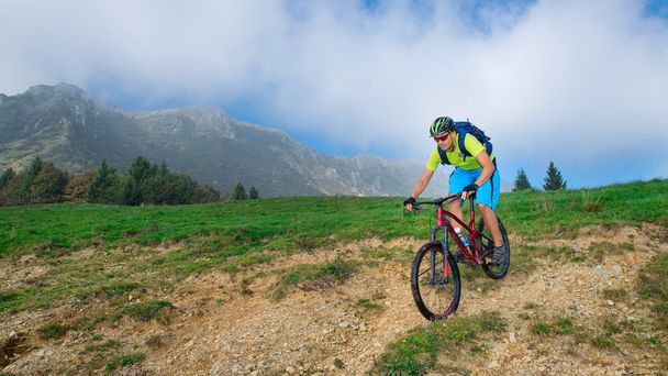 ένας ημιτελής κούρος ιππασίας ένα ποδήλατο βουνού, υπαίθρια - Φωτογραφία, εικόνα