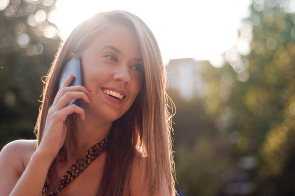 Happy young lady talking on mobile phone - Foto, imagen