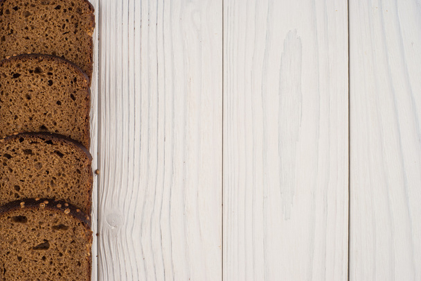 Rye bread on an old white wooden table.  - Foto, afbeelding