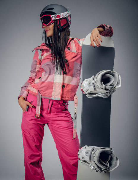 Female in a pink ski costume holding a snowboard - Foto, Imagem