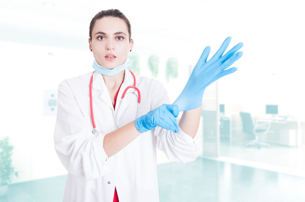 Attractive medic putting gloves on - Fotoğraf, Görsel