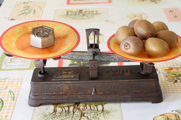 viejo balanza de dos sartenes con kiwis
 - Foto, Imagen