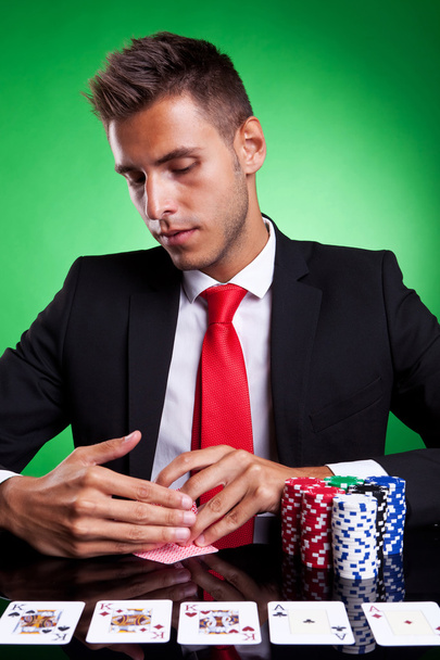 Pokerspieler sieht sich in die Karten - Foto, Bild
