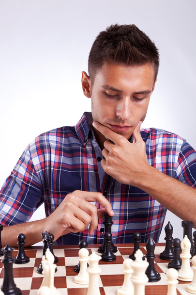 Jovem jogador de xadrez pensando em seu próximo movimento
 - Foto, Imagem