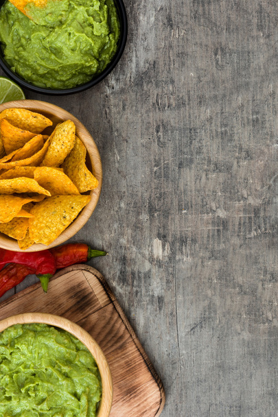 Nachos, guacamole and ingredients on wooden background - Фото, зображення